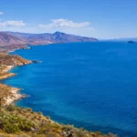Vue panoramique de la mer de Cortés en Basse-Californie avec désert côtier, montagnes arides et baleine au large dans les eaux turquoise
