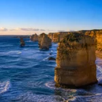 Falaises des Douze Apôtres en Australie au coucher du soleil avec piliers rocheux et vagues océaniques