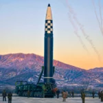 Missile balistique intercontinental nord-coréen sur une base militaire entouré de soldats dans un paysage montagneux