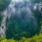 Vue aérienne réaliste du gouffre Xiaozhai Tiankeng en Chine avec une jungle dense au fond de la cavité et des falaises calcaires abruptes