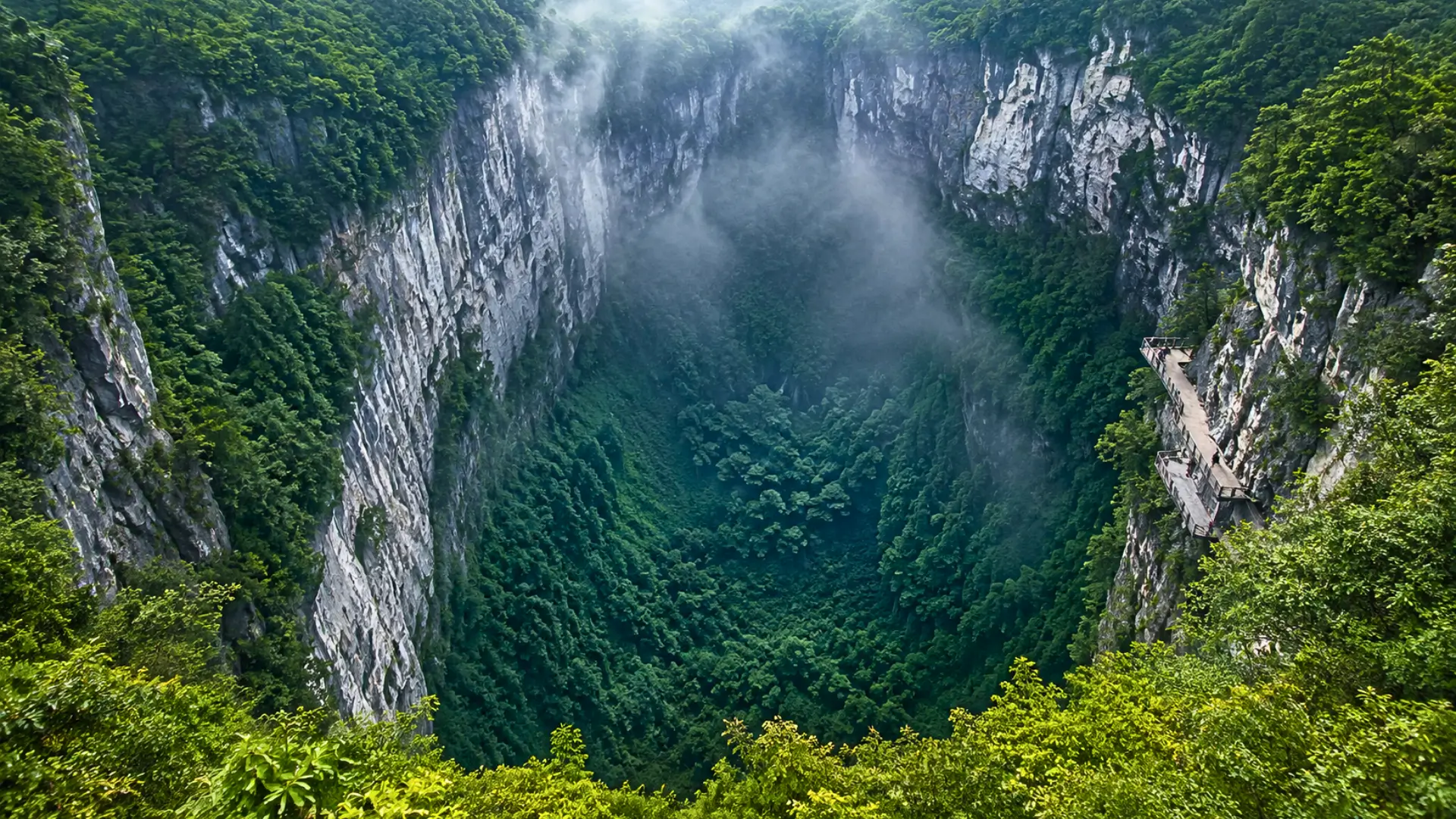 Vue aérienne réaliste du gouffre Xiaozhai Tiankeng en Chine avec une jungle dense au fond de la cavité et des falaises calcaires abruptes