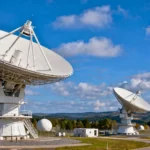 Stations sol satellitaires avec grandes antennes paraboliques dans un site sécurisé européen.