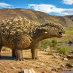 Pinacosaurus cuirassé au bord d’une rivière dans un paysage crétacé, la bouche entrouverte comme s’il émettait un appel.