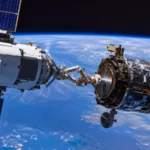 Un véhicule spatial européen approche un satellite en orbite basse avec un bras robotique de capture, au-dessus de la Terre.