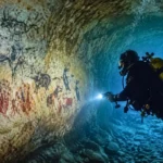 Grotte sous-marine ornée éclairée par un plongeur dans les calanques de Marseille.