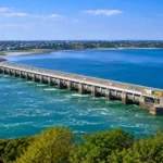 Vue aérienne de la centrale marémotrice de la Rance reliant les rives entre Saint-Malo et Dinard, avec l’estuaire et les eaux de marée.