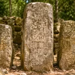 Trois stèles mayas érodées au cœur d’un site archéologique forestier.