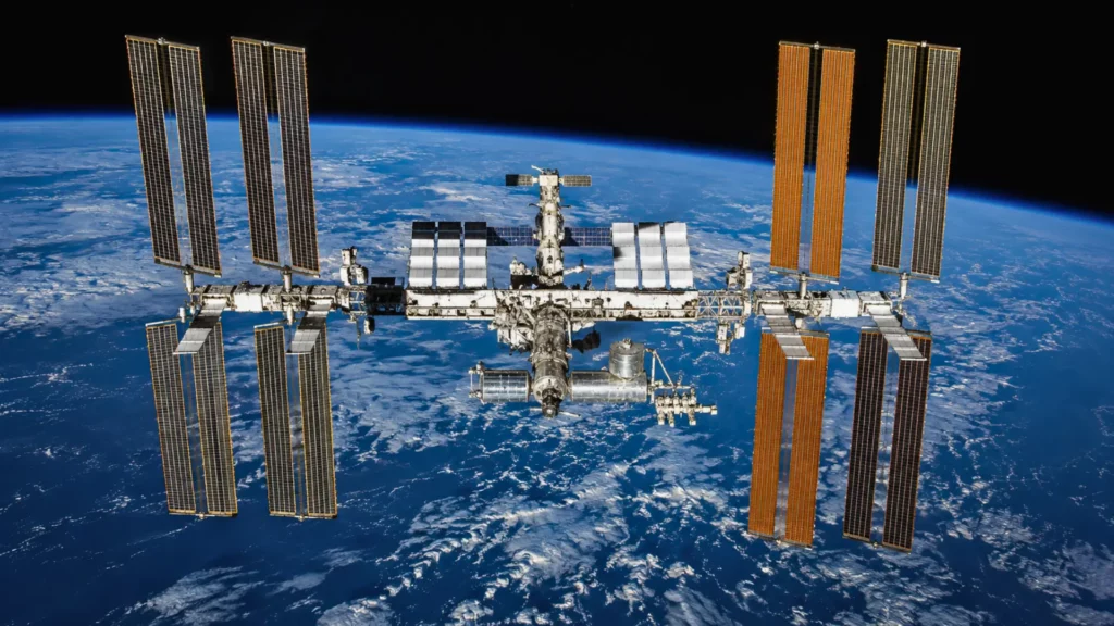 Vue réaliste de la Station spatiale internationale en orbite au-dessus de la Terre, illustrant les tensions autour de la fuite du module russe Zvezda.