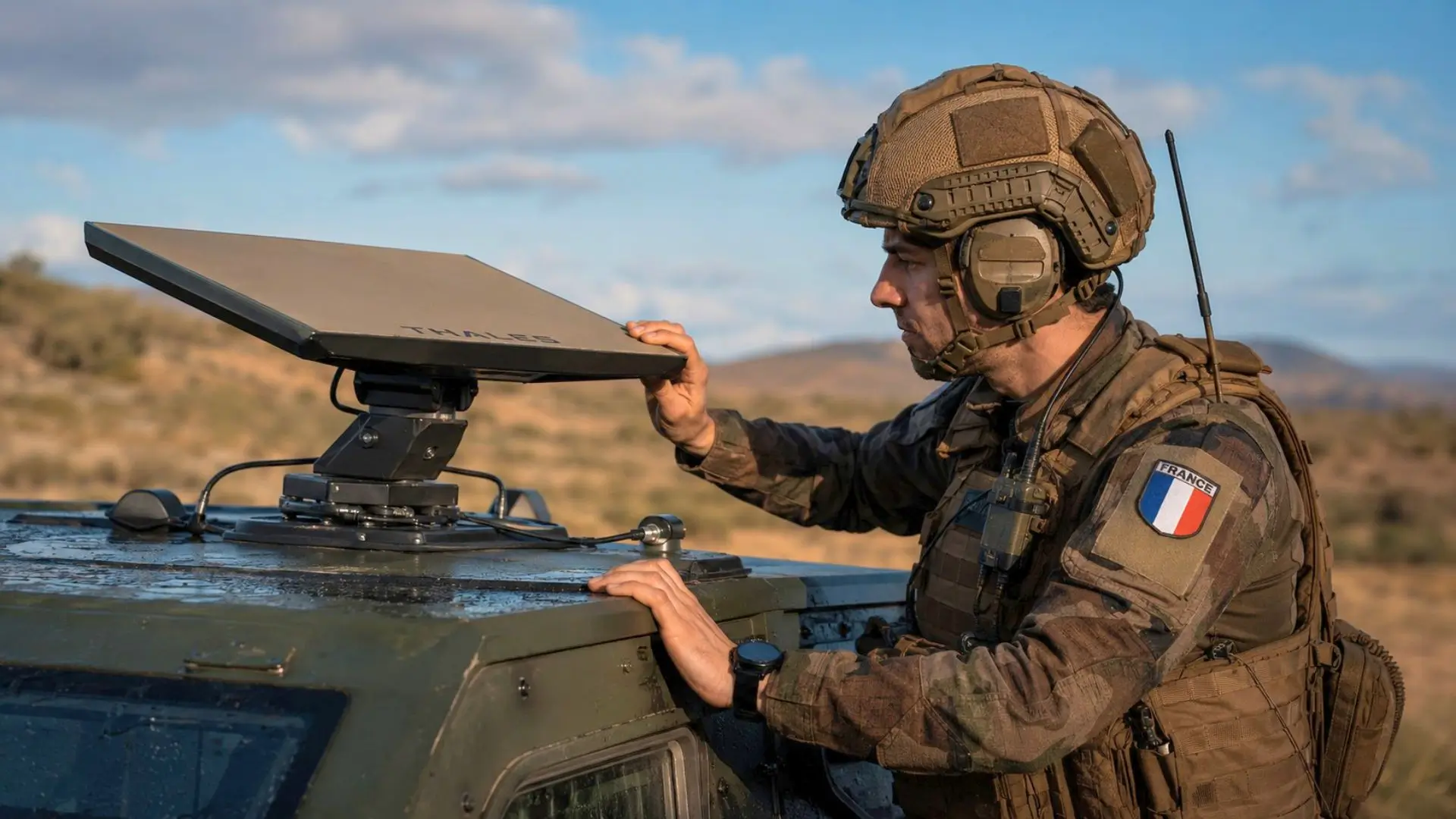 Un soldat français ajuste une antenne satellite intelligente installée sur un véhicule militaire en opération.