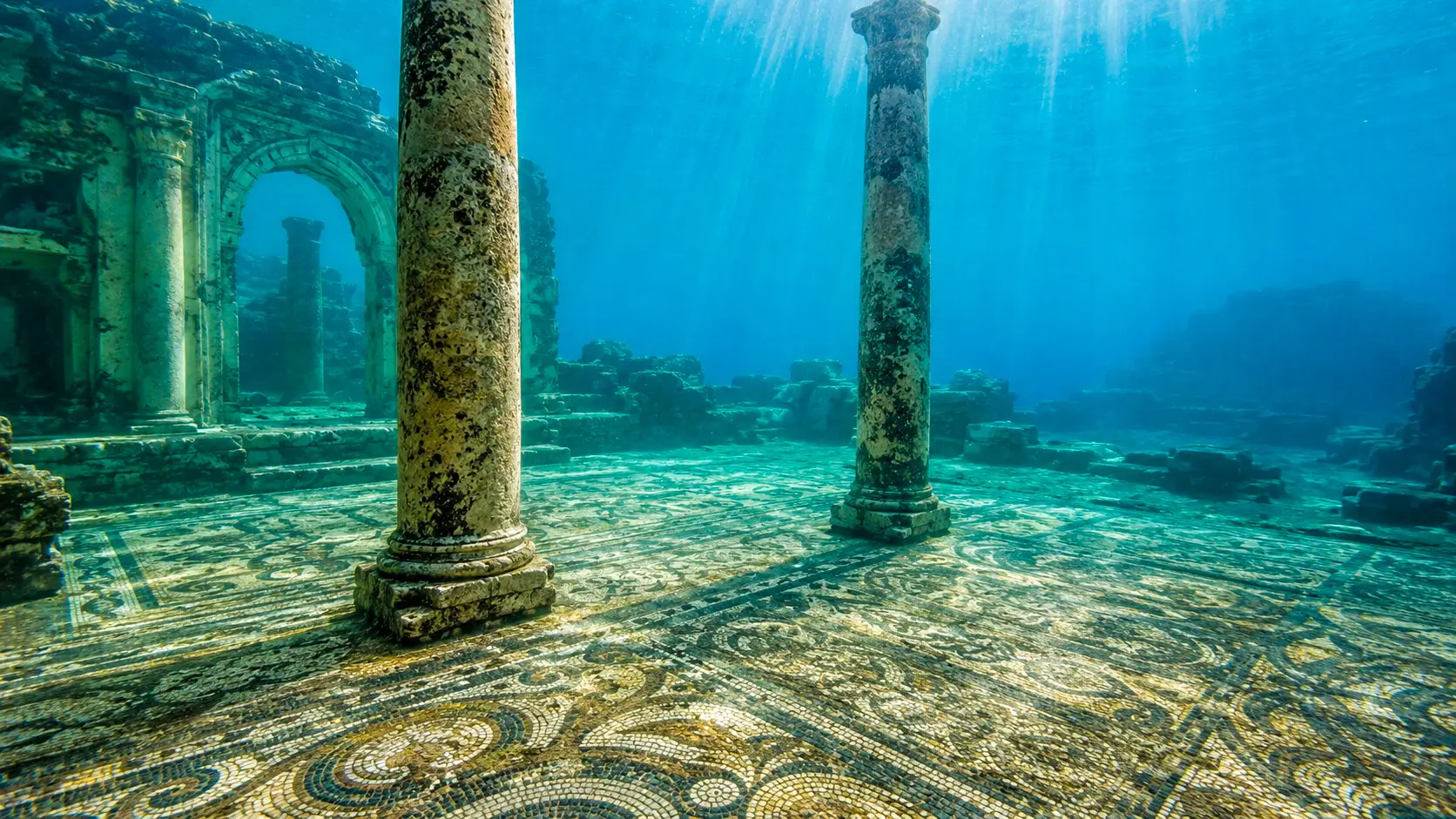 Ruines romaines englouties de Baïes avec colonnes antiques et vaste sol en mosaïque préservé sous la mer.