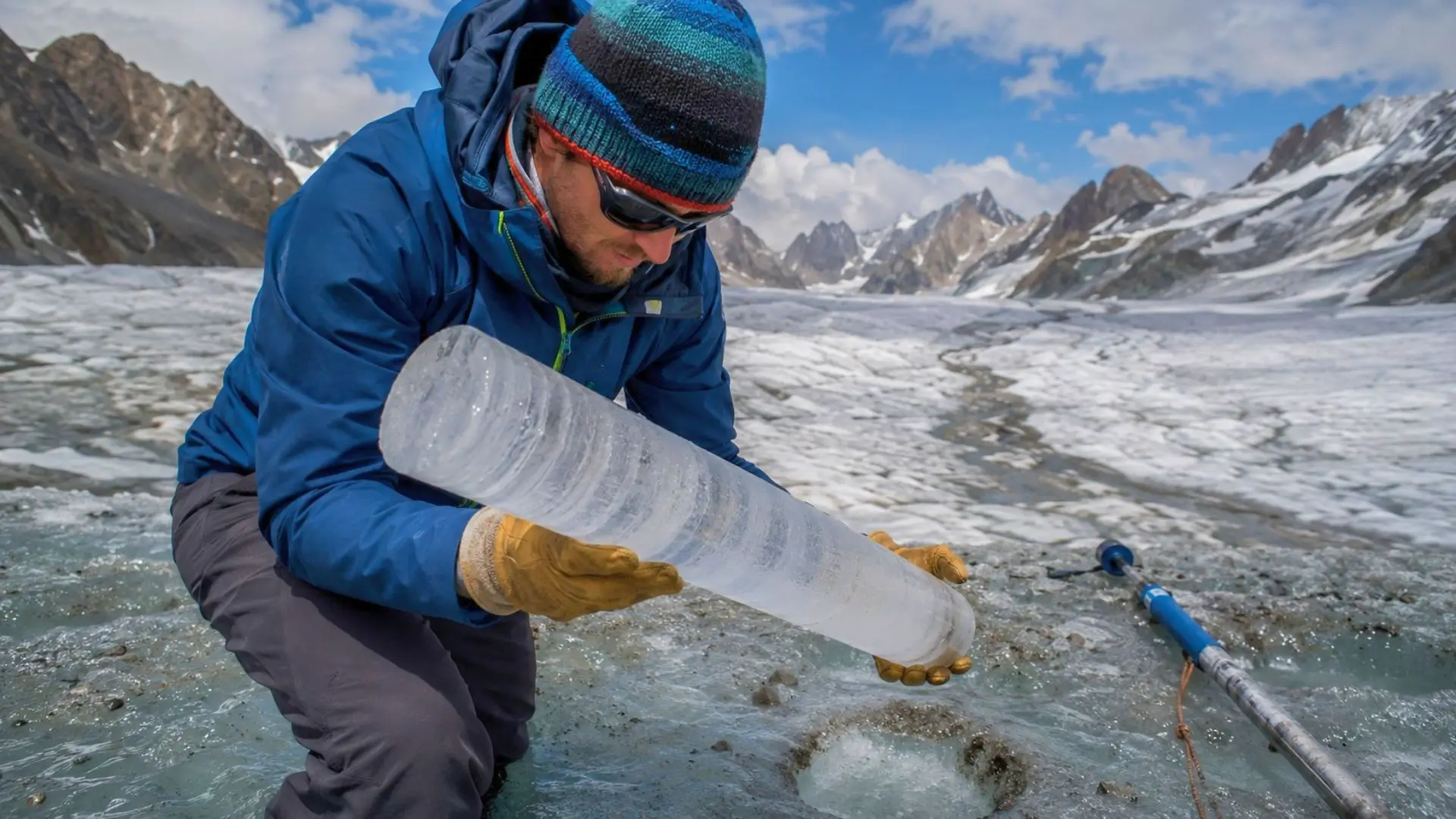 Un glaciologue examine une carotte de glace extraite d’un glacier alpin en pleine fonte.