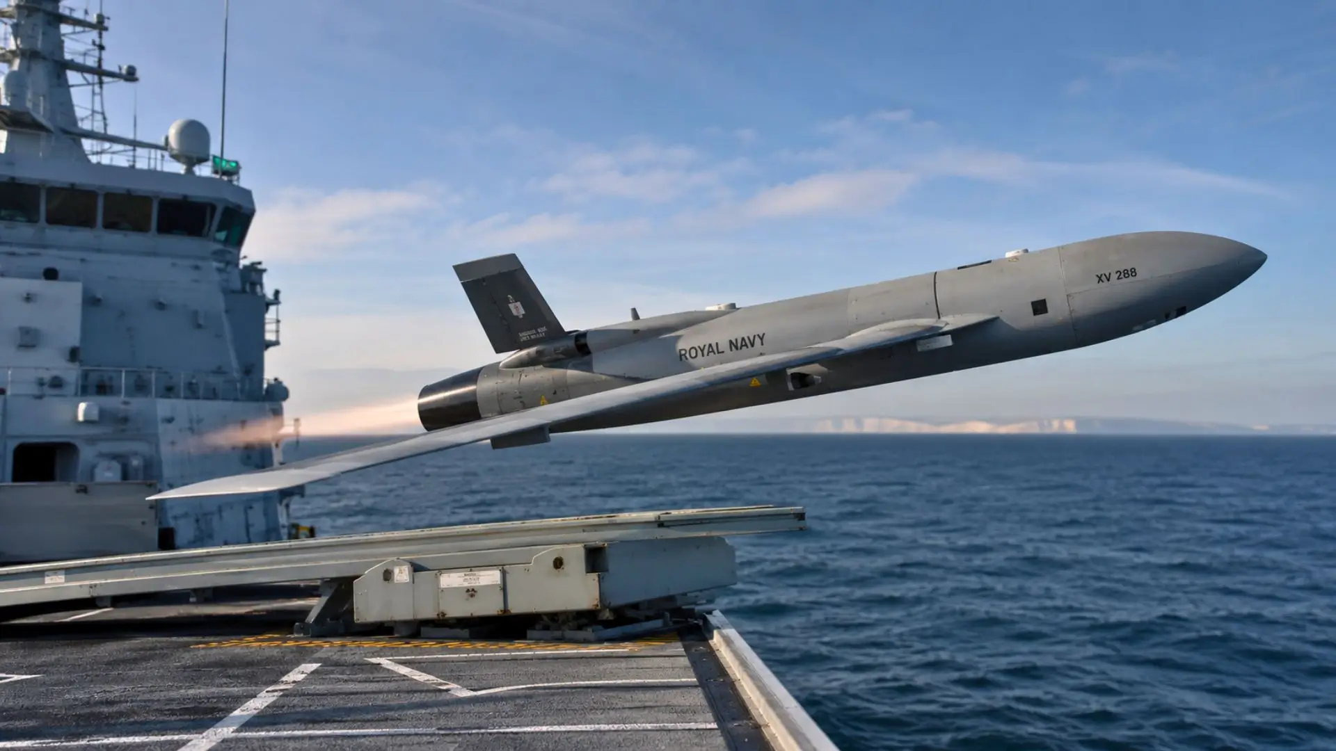Un drone militaire autonome décolle depuis le pont d’un navire de la Royal Navy en pleine mer.