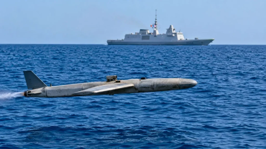 Un drone militaire low-cost vole au ras de la mer Rouge, avec une frégate française visible à l’horizon.