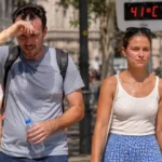 Un homme très affecté par la chaleur marche aux côtés d’une femme plus résistante lors d’une canicule à 41 °C en ville.
