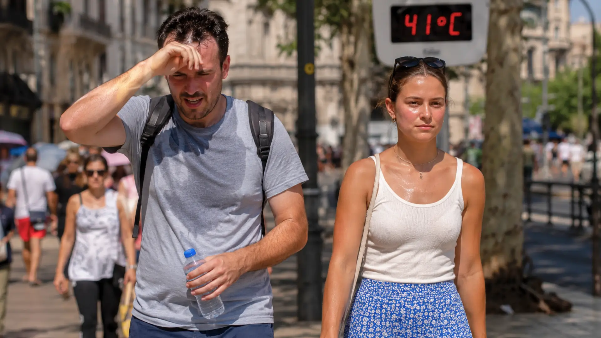 Un homme très affecté par la chaleur marche aux côtés d’une femme plus résistante lors d’une canicule à 41 °C en ville.