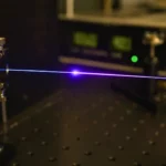 Une fibre optique traversée par une impulsion laser lumineuse au cœur d’un dispositif expérimental en laboratoire.