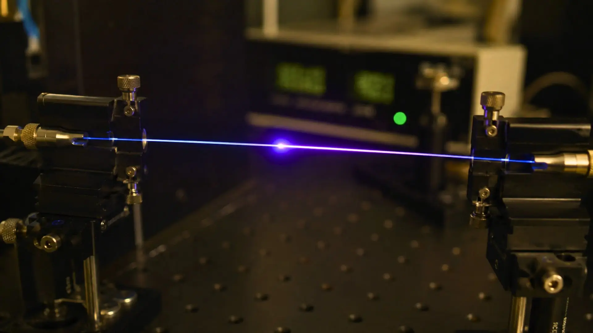 Une fibre optique traversée par une impulsion laser lumineuse au cœur d’un dispositif expérimental en laboratoire.