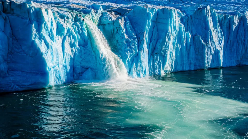 De l’eau de fonte s’écoule d’un glacier du Groenland et forme une vaste plume claire dans les eaux sombres de l’Atlantique Nord.