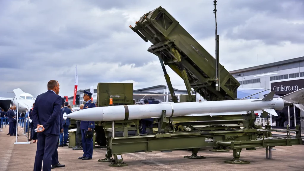Missile Patriot PAC-3 ACE exposé sur un lanceur au salon aéronautique de Farnborough, sous un ciel couvert, entouré de visiteurs et de personnels militaires.