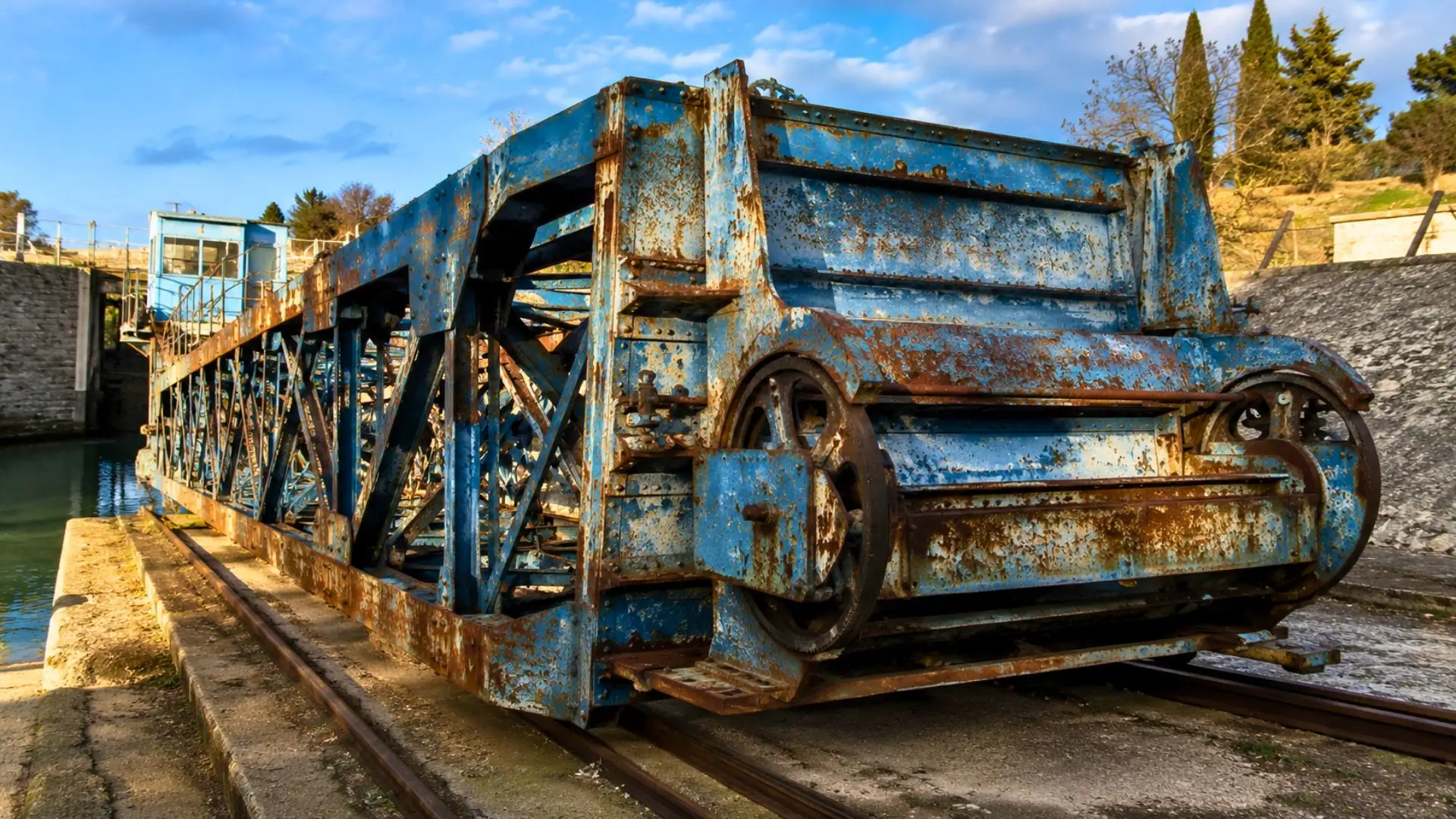 L’ancienne machine bleue et rouillée de la pente d’eau de Fonseranes, abandonnée sur ses rails près du canal du Midi.