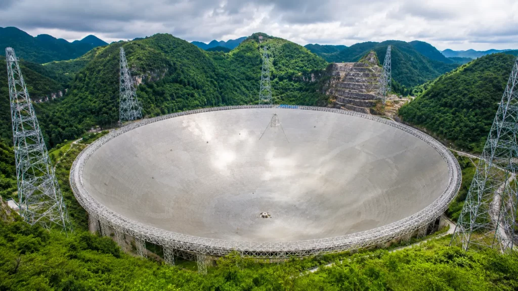 Le radiotélescope géant FAST de 500 mètres niché au cœur des montagnes verdoyantes du Guizhou, en Chine.