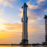 La fusée Starship dressée sur son pas de tir à Starbase, sous un ciel doré, avant une future mission vers Mars.