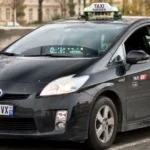 Un taxi Toyota Prius noir à Paris affiche près de 500 000 kilomètres au compteur, symbole de fiabilité mécanique.