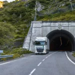 Un poids lourd circule devant l’entrée du tunnel du Somport, relié côté français par une route de montagne à deux voies.