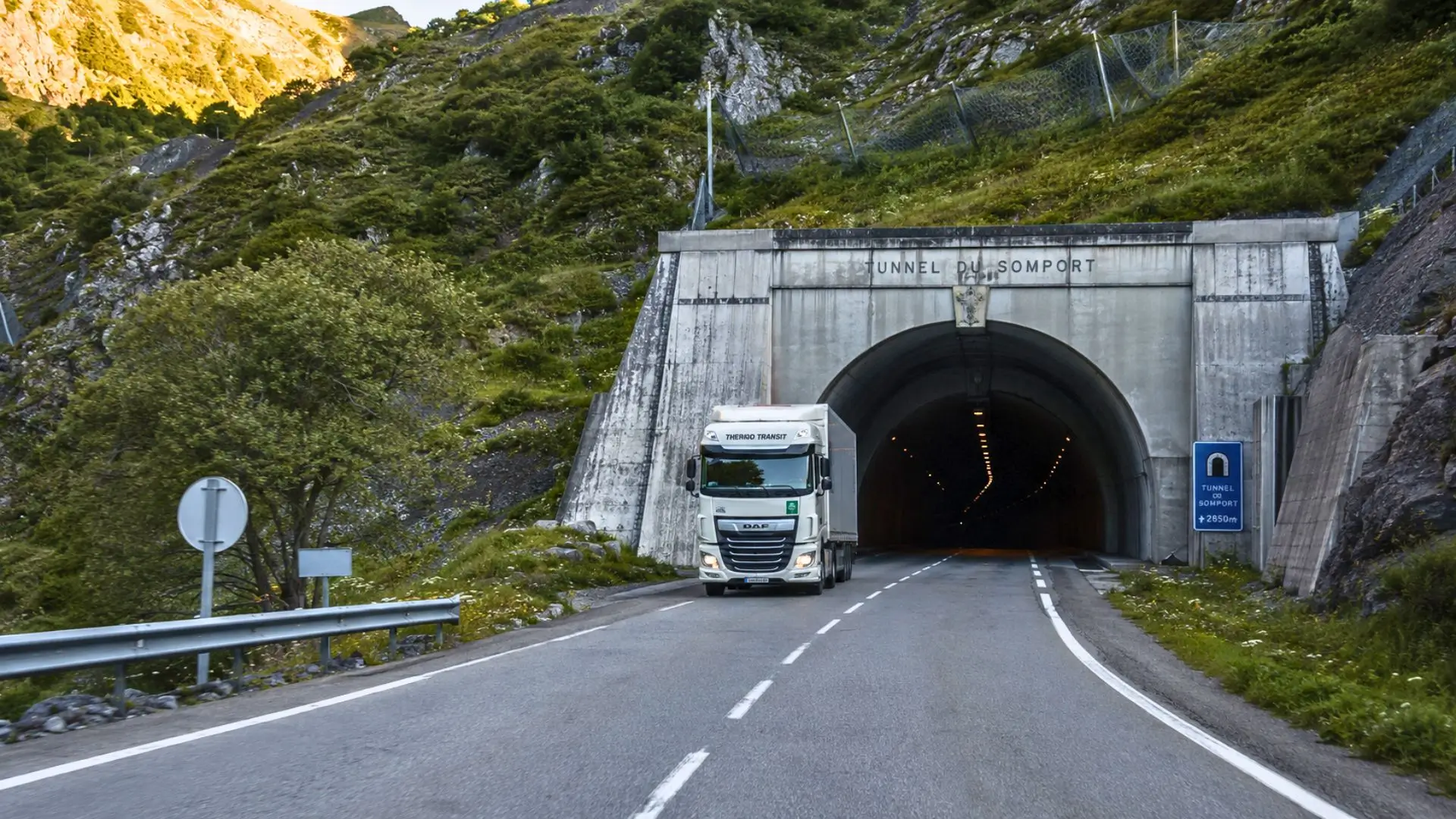 Un poids lourd circule devant l’entrée du tunnel du Somport, relié côté français par une route de montagne à deux voies.