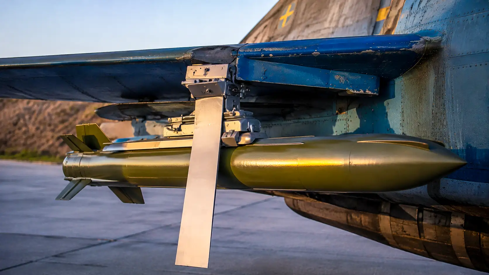 Une bombe planante Equalizer de conception ukrainienne fixée sous l’aile d’un avion de combat sur une base aérienne.
