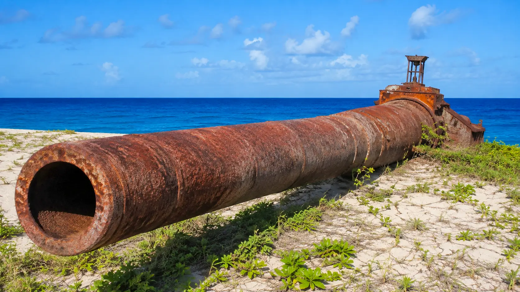 Un immense canon rouillé du projet HARP repose sur une plage de la Barbade face à la mer des Caraïbes.