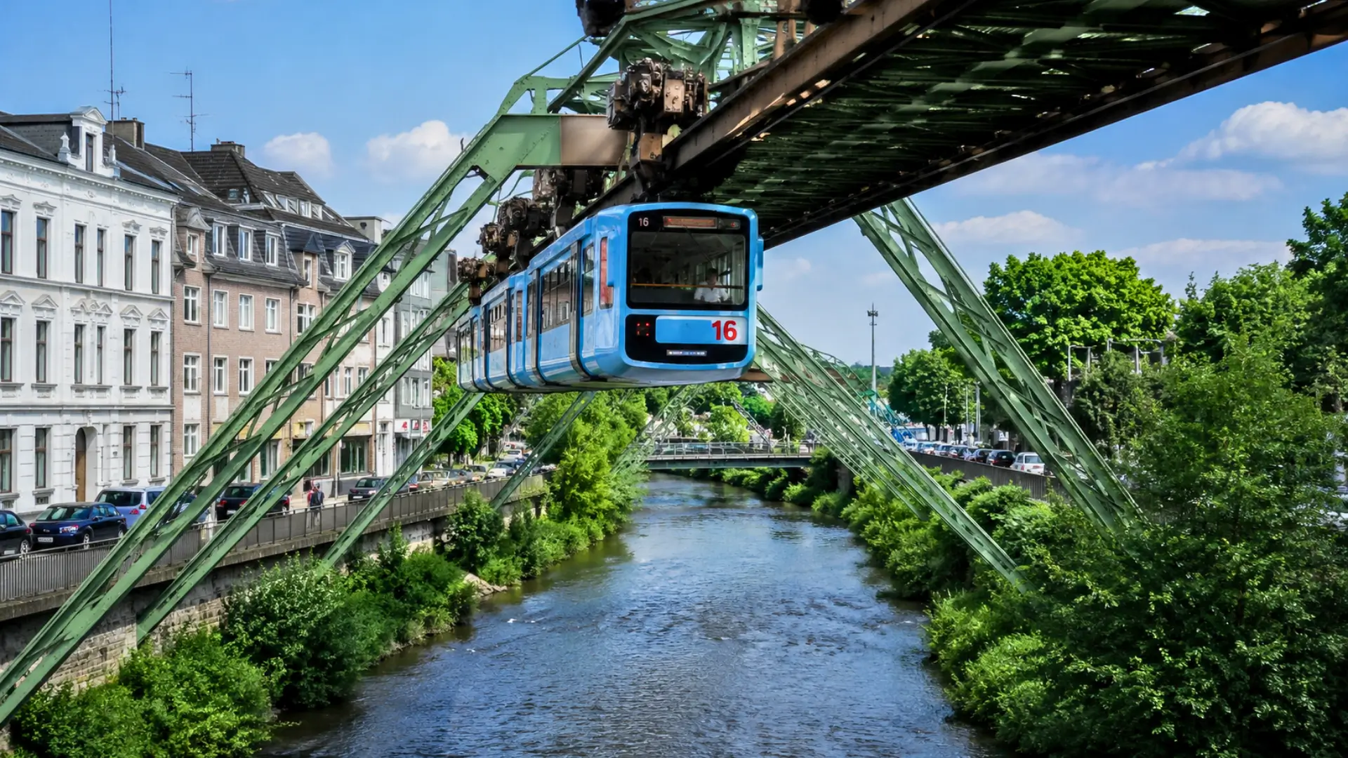Le monorail suspendu Schwebebahn traverse Wuppertal au-dessus de la rivière Wupper, sous sa structure métallique historique, en pleine journée.