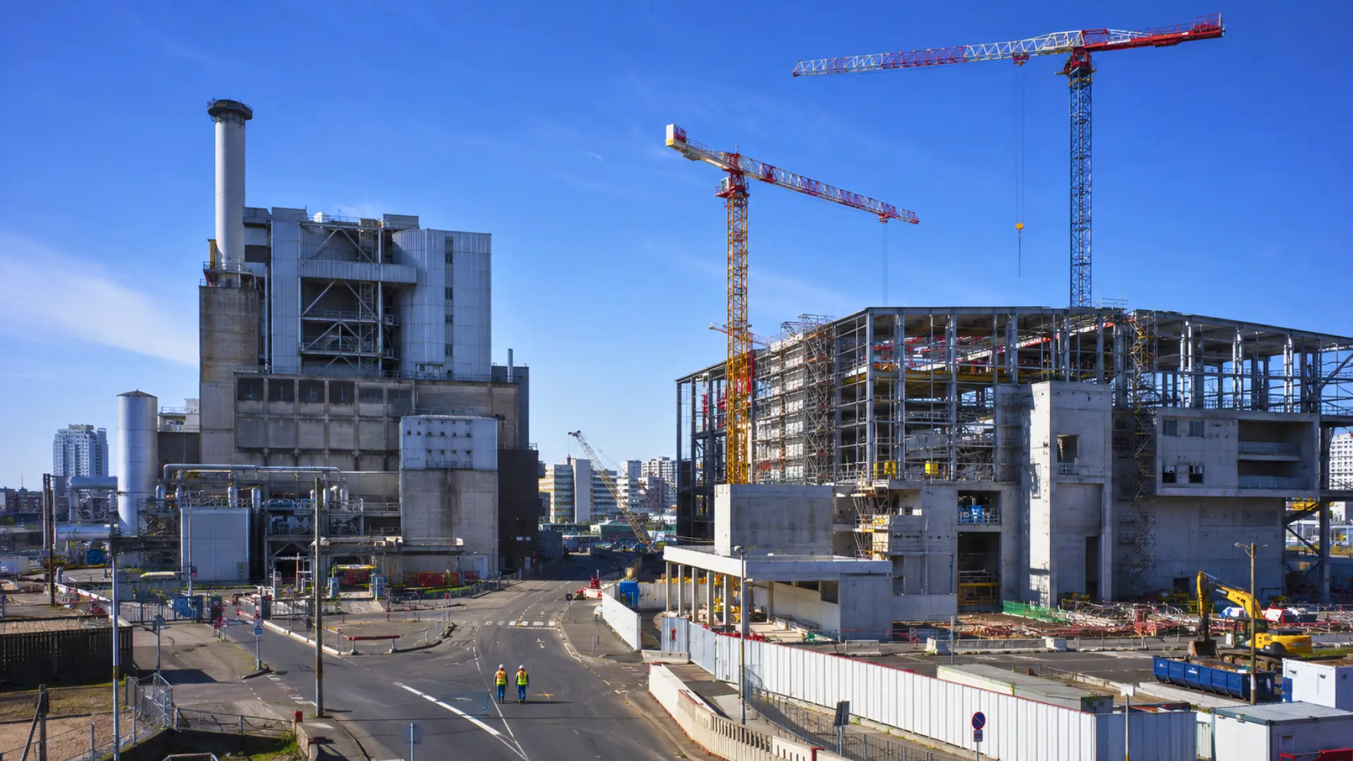 Vue réaliste du site d’Ivry-Paris XIII avec l’ancien incinérateur à gauche et le chantier de la nouvelle usine L’Interval à droite, près de Paris.