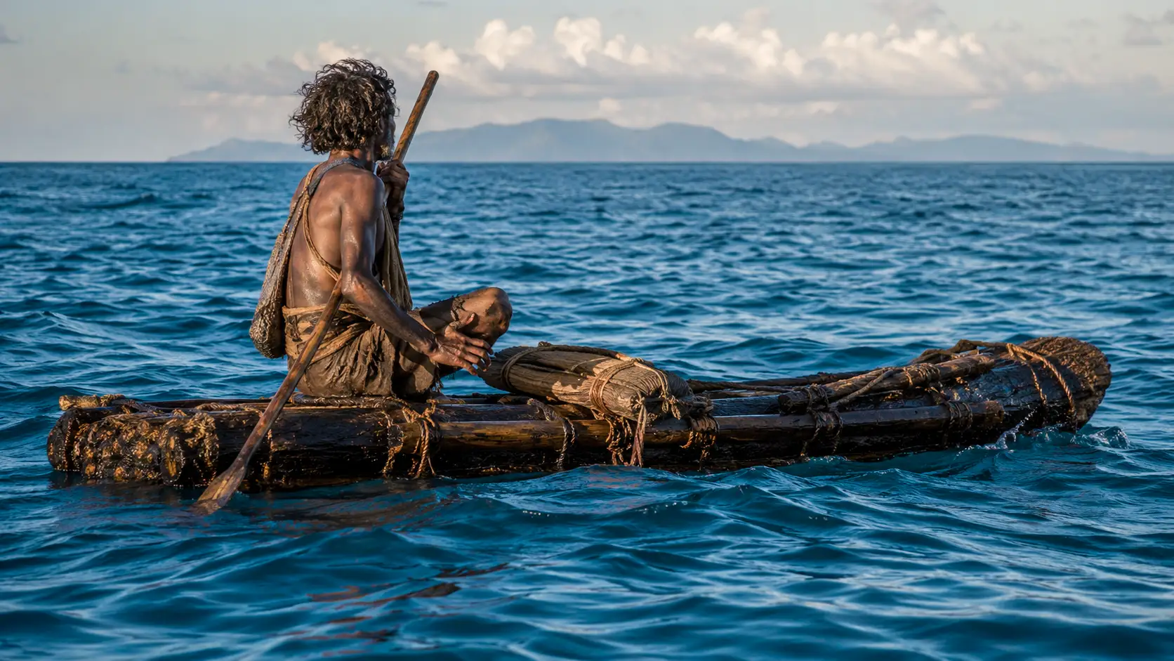 Un homme préhistorique navigue sur un radeau rudimentaire en pleine mer, avec une île montagneuse visible à l’horizon.
