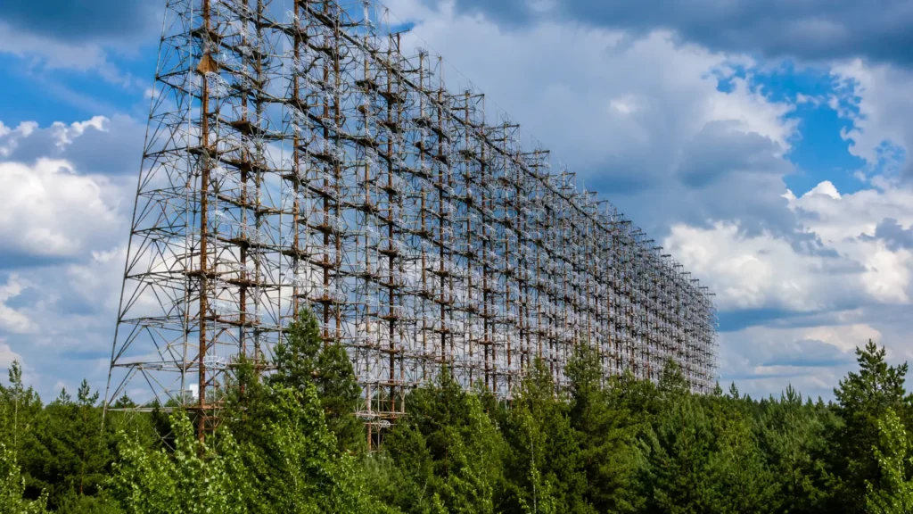Le gigantesque radar soviétique Duga domine la forêt de Tchernobyl, sa structure d’acier rouillée s’étendant au-dessus de la canopée.