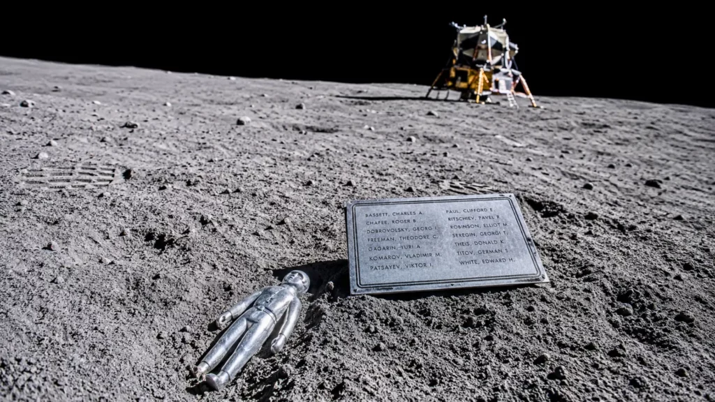 La sculpture Fallen Astronaut et sa plaque commémorative posées dans la poussière lunaire près du module Apollo 15.
