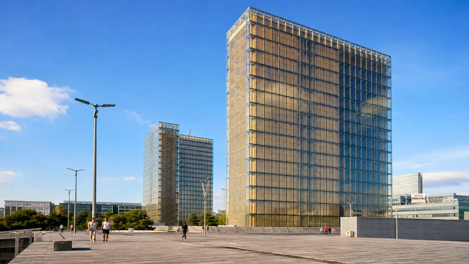 Tours vitrées de la Bibliothèque nationale de France à Paris, avec façades transparentes et protections intérieures en bois visibles derrière le verre.