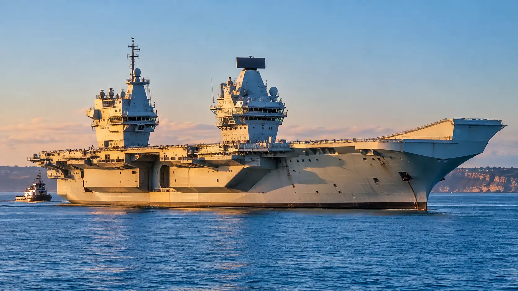 Le porte-avions britannique HMS Prince of Wales immobilisé en mer, escorté par un remorqueur après une panne de propulsion.