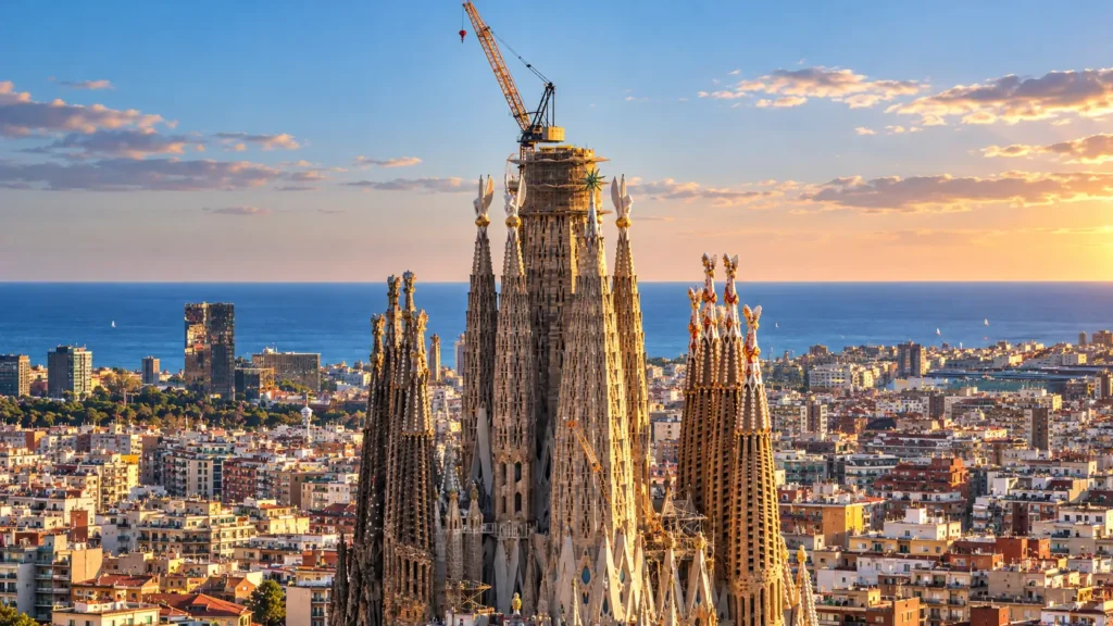 La Sagrada Família domine Barcelone avec ses tours monumentales et une grue encore visible au sommet du chantier.